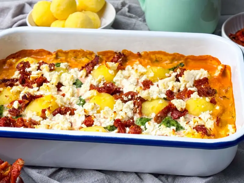 Herzhafter griechischer Spinat Feta Auflauf mit Kartoffeln und getrockneten Tomaten, frisch aus dem Ofen.